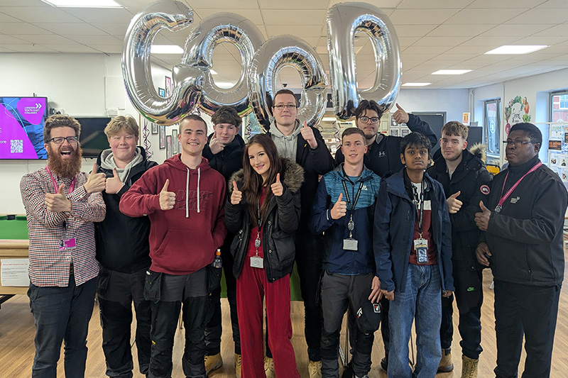 students in the common room with silver balloons spelling out GOOD