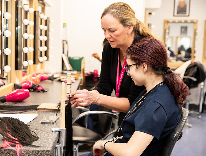 Tutor talking to a student in the hair and beauty salon