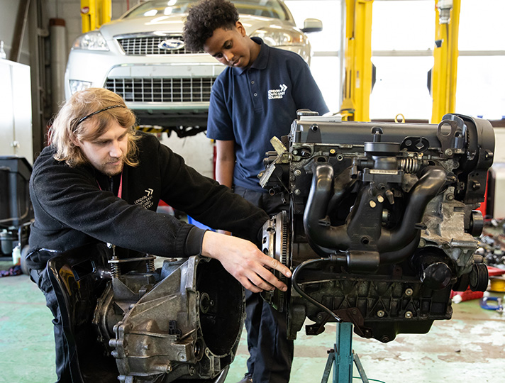 Students inspecting a car engine